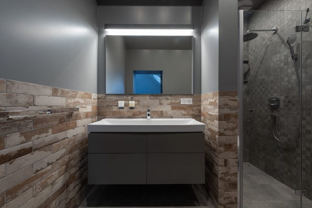 Contemporary bathroom with a glass shower and illuminated mirror.